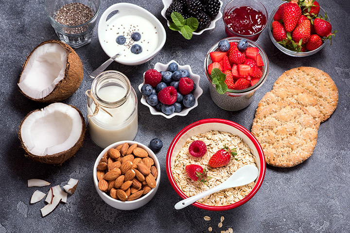 Healthy vegan breakfast with coconut yogurt, muesli, chia pudding, crisp bread, almonds, berries. Balanced diet and healthy eating concept, morning meal, copy space background